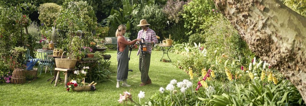 Zwei Personen im Garten mit Heckenschere